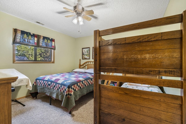 carpeted bedroom featuring a textured ceiling and ceiling fan