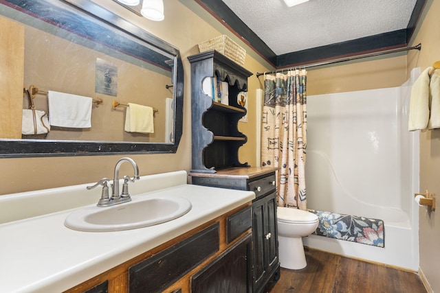 full bathroom with toilet, hardwood / wood-style floors, shower / bath combination with curtain, vanity, and a textured ceiling