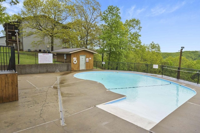 view of pool featuring a patio and an outbuilding