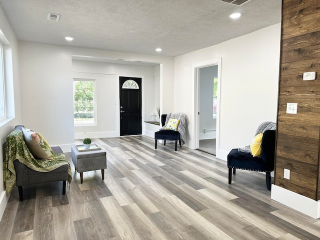 sitting room featuring light wood-type flooring and a textured ceiling