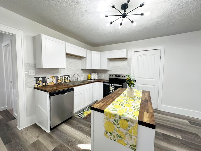 kitchen with appliances with stainless steel finishes, butcher block countertops, white cabinets, and dark hardwood / wood-style floors