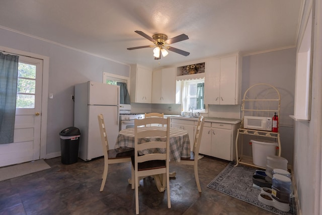 kitchen with white appliances, ceiling fan, white cabinets, and a healthy amount of sunlight