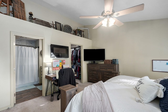 carpeted bedroom featuring lofted ceiling, a spacious closet, a closet, and ceiling fan