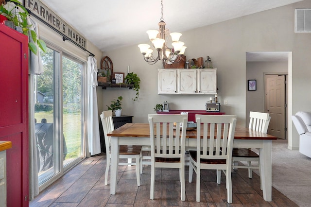 carpeted dining area featuring vaulted ceiling and an inviting chandelier