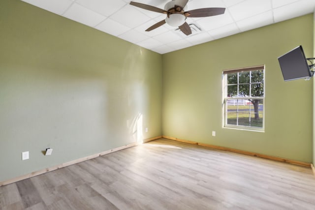 spare room with a drop ceiling, ceiling fan, and light hardwood / wood-style floors