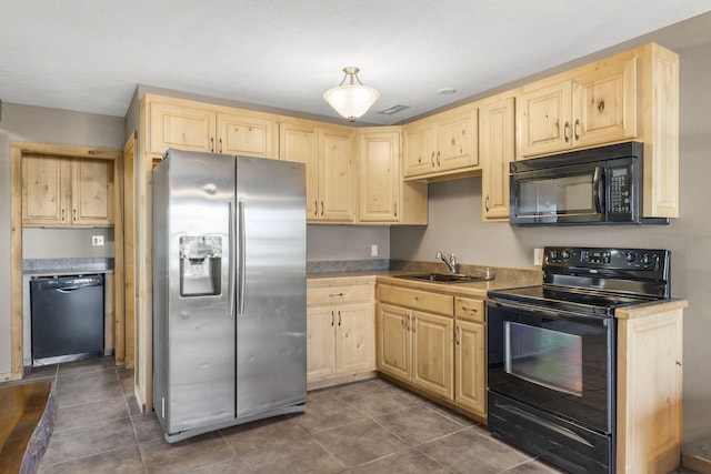 kitchen featuring light brown cabinetry, sink, dark tile patterned floors, and black appliances