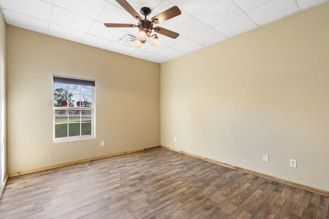 empty room with a paneled ceiling, ceiling fan, and light hardwood / wood-style flooring