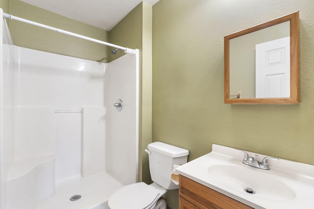 bathroom featuring vanity, toilet, a textured ceiling, and curtained shower