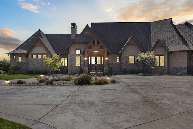 view of front of property with stone siding and a chimney