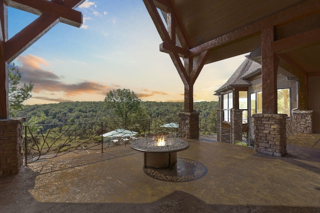 patio terrace at dusk featuring an outdoor fire pit