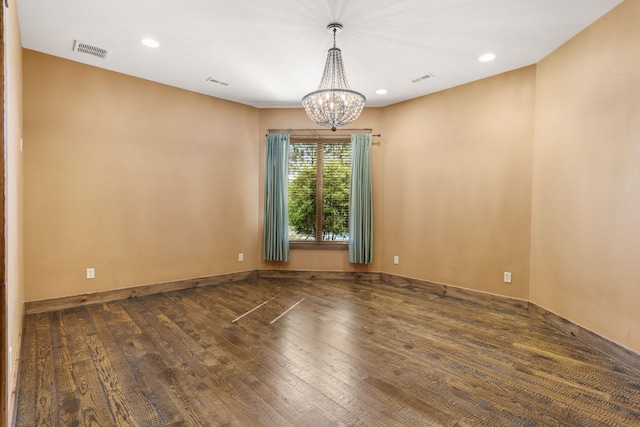 spare room featuring recessed lighting, wood finished floors, visible vents, baseboards, and a notable chandelier