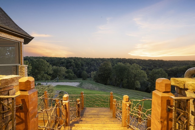yard at dusk with a wooded view