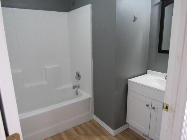 bathroom featuring shower / bathing tub combination, wood-type flooring, and vanity