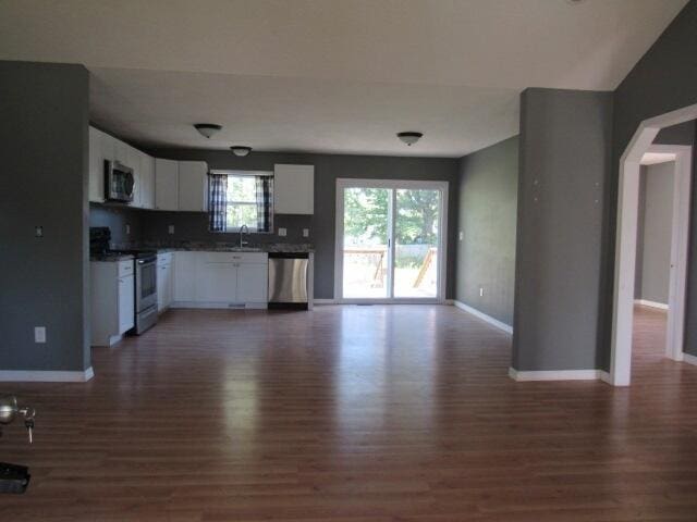 unfurnished living room with dark hardwood / wood-style floors and sink