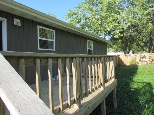 view of property exterior featuring a yard and a deck