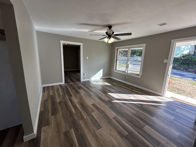 spare room featuring dark wood-type flooring, a healthy amount of sunlight, and ceiling fan