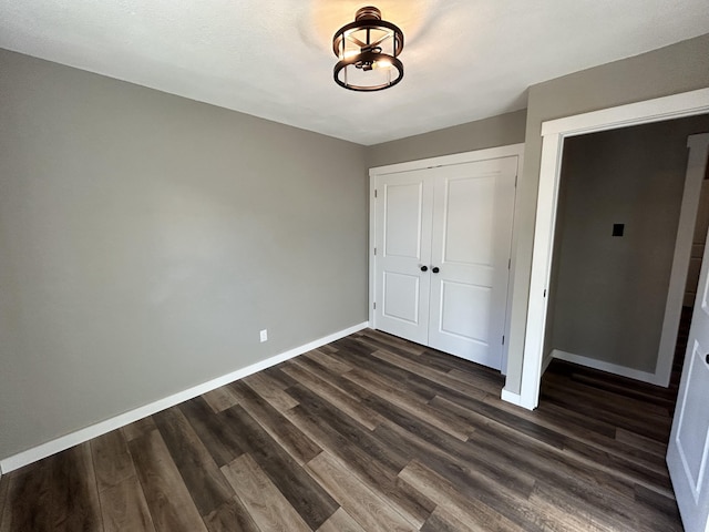 unfurnished bedroom featuring dark wood-type flooring and a closet