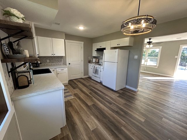 kitchen with white appliances, dark hardwood / wood-style floors, white cabinetry, and decorative light fixtures