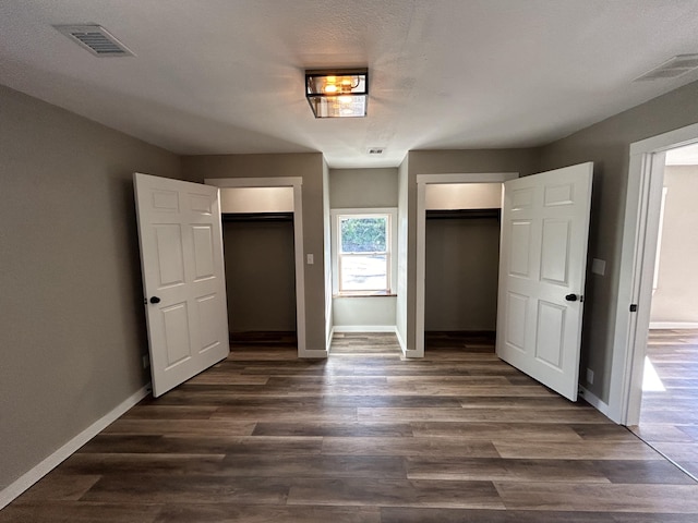 unfurnished bedroom featuring dark wood-type flooring and a textured ceiling