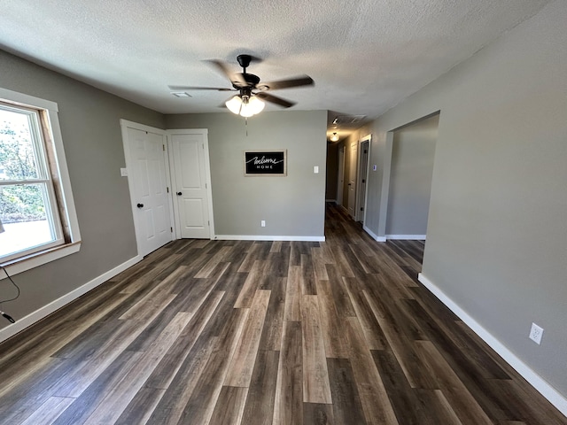 spare room with a textured ceiling, dark hardwood / wood-style floors, and ceiling fan