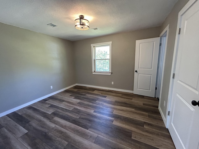 unfurnished bedroom with dark wood-type flooring and a textured ceiling