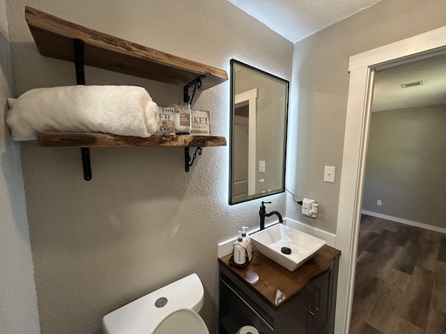 bathroom with hardwood / wood-style floors, vanity, and toilet