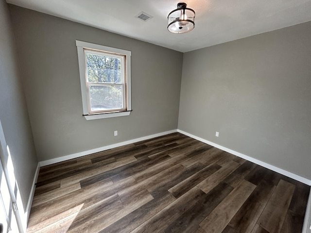 unfurnished room with dark wood-type flooring