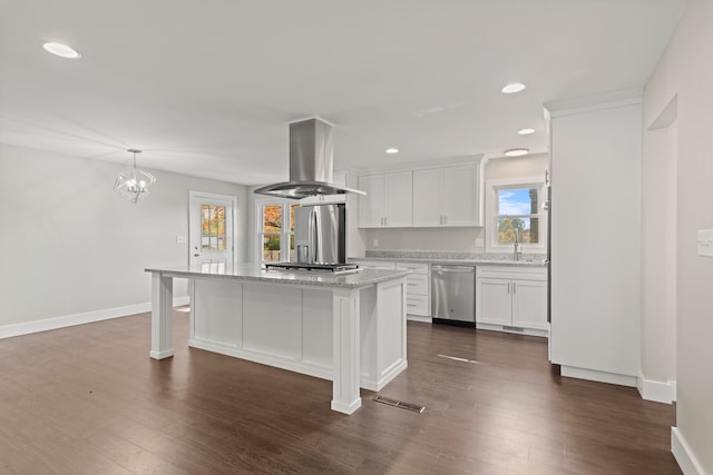 kitchen with island range hood, a center island, white cabinets, appliances with stainless steel finishes, and dark hardwood / wood-style flooring