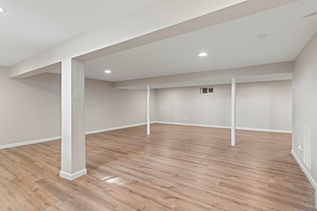 basement with light hardwood / wood-style flooring