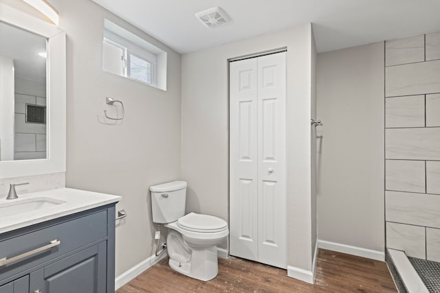 bathroom with vanity, toilet, and hardwood / wood-style floors