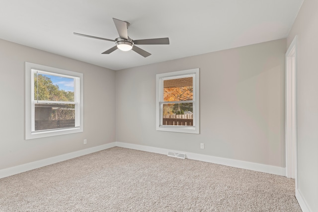 carpeted spare room featuring ceiling fan