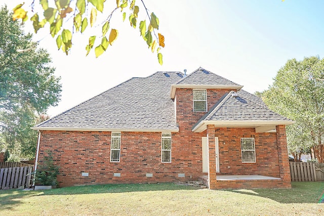 back of house featuring a lawn and a patio area