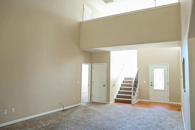 carpeted foyer with a high ceiling