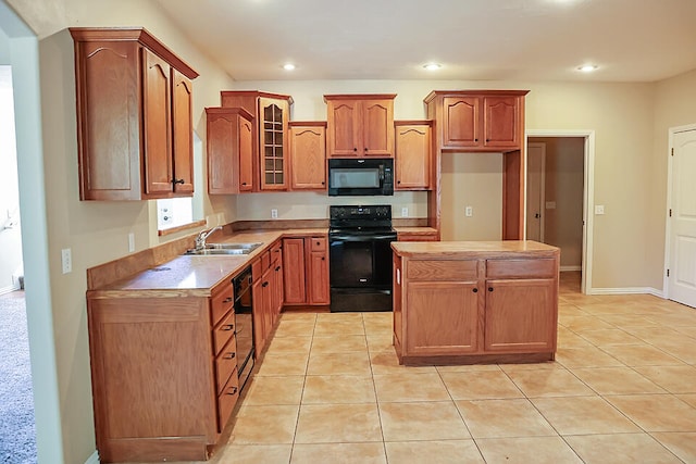 kitchen with light tile patterned flooring, a kitchen island, sink, and black appliances