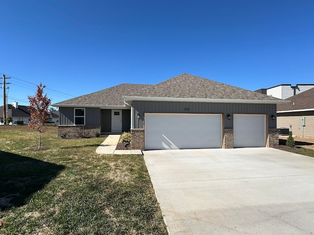 view of front of home featuring central air condition unit, a front lawn, and a garage