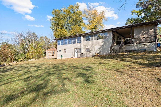 back of property with a yard and a storage unit