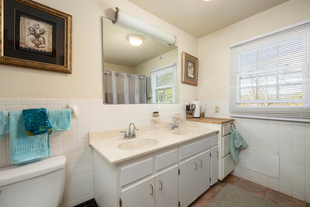 bathroom featuring plenty of natural light, tile walls, vanity, and toilet