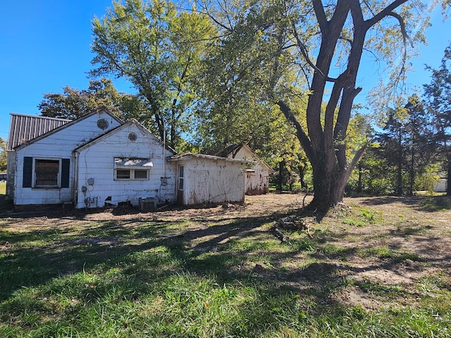 view of side of property featuring central air condition unit and a yard