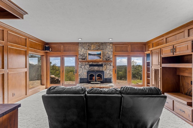 living room featuring plenty of natural light, carpet, wooden walls, and a textured ceiling