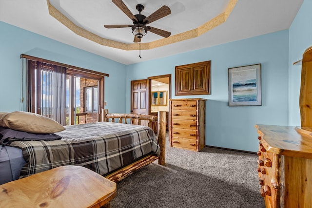 carpeted bedroom featuring a tray ceiling and ceiling fan