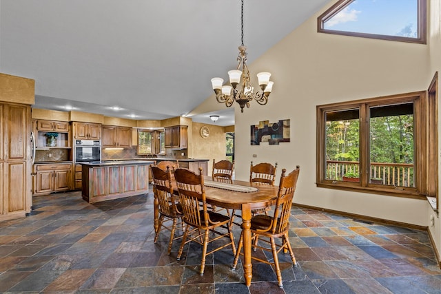 dining space featuring an inviting chandelier, high vaulted ceiling, and a healthy amount of sunlight