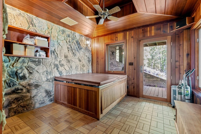 interior space featuring ceiling fan, wood ceiling, vaulted ceiling, wooden walls, and light parquet flooring