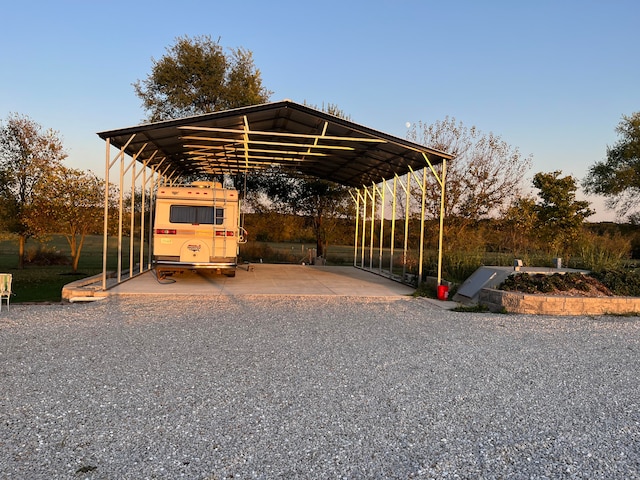 parking at dusk featuring a carport