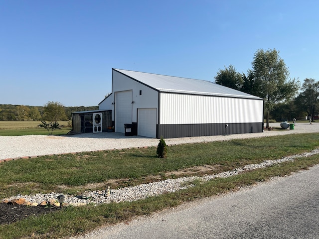 view of outdoor structure featuring a garage, a lawn, and a carport