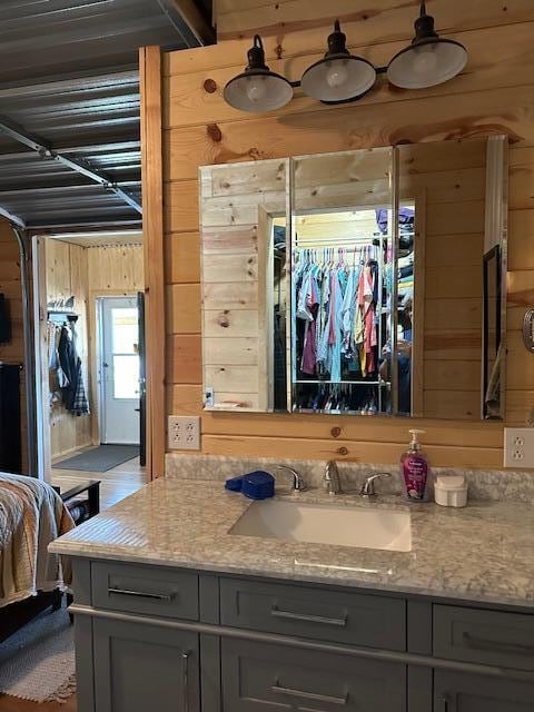 bathroom with vanity and wooden walls