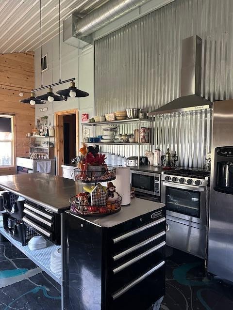 kitchen with wall chimney exhaust hood, wooden walls, and stainless steel appliances