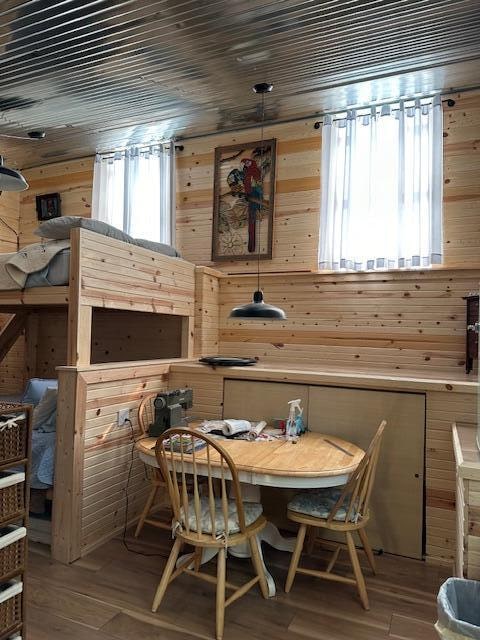 dining area with wood-type flooring and wood walls