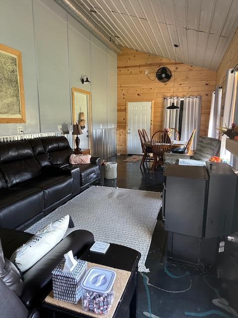 living room with wood walls, vaulted ceiling, and wooden ceiling