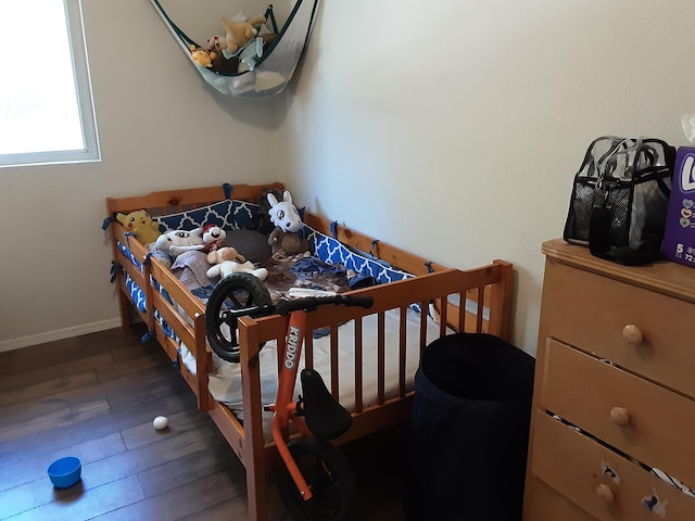 bedroom featuring hardwood / wood-style flooring and baseboards