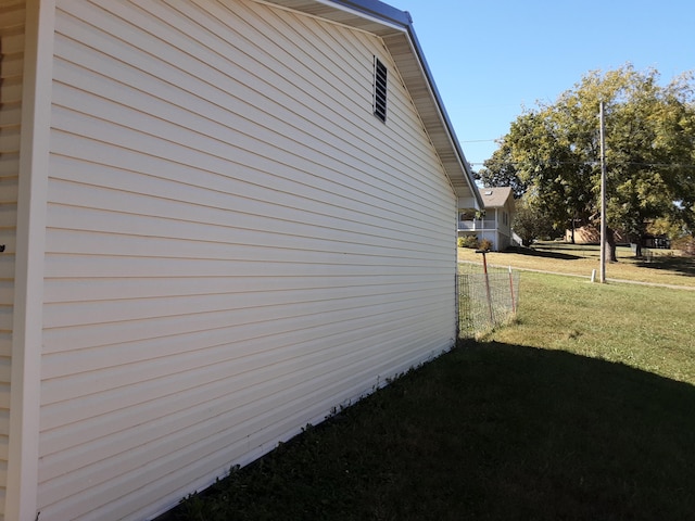 view of side of home featuring a yard and fence